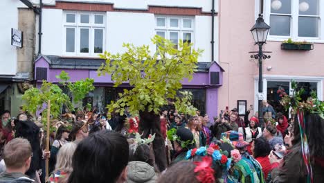 Crowds-of-people-watching-Beltane-May-Day-art-performance-celebrating-the-beginning-of-summer-and-power-of-life-force-in-Glastonbury-town,-Somerset-UK