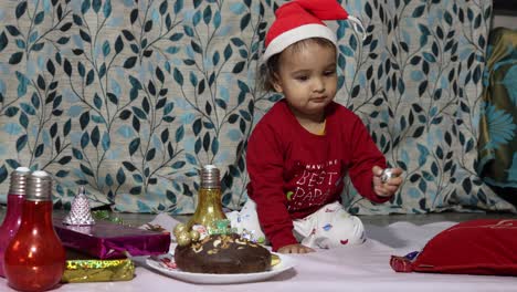 cute-infant-enjoying-Christmas-eve-celebration-at-home-at-night-from-different-angle