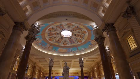 Tilt-Down-Shot-From-Ornate-Ceiling-Inside-Caesars-Palace-Casino-With-Statues-In-Lobby