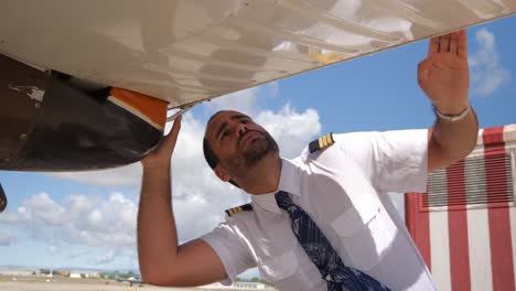 A-pilot-checks-under-his-plane-before-takes-off