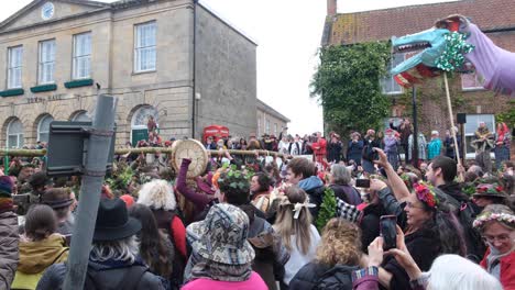 The-maypole-making-its-way-through-busy-crowds-of-people-in-Glastonbury-town-during-Beltane-May-Day-celebration-in-Somerset-UK