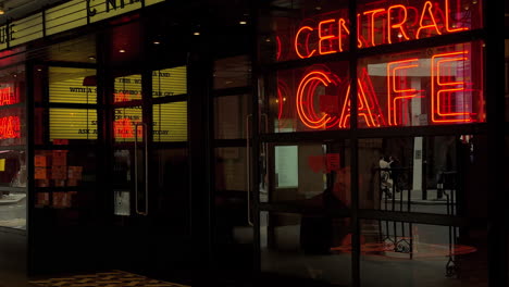 Entrance-to-Picturehouse-Central,-Man-reads-in-Cafe,-Mid-Shot,-London,-Day