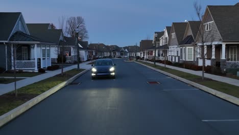 Tesla-Model-Y-driving-through-modern-neighborhood-at-night