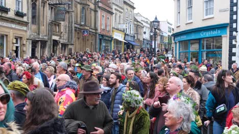 Packed-streets-with-crowds-of-people-celebrating-Beltane-May-Day,-the-beginning-of-summer,-in-Glastonbury-town,-Somerset-UK