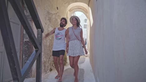 Junges-Paar-Hand-In-Hand-Machen-Einen-Romantischen-Spaziergang-Durch-Die-Seitengassen-Von-Mykonos,-Griechenland