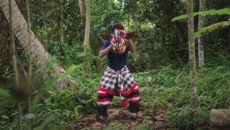 Amidst-the-jungle's-embrace,-a-Balinese-dancer-embodies-ancestral-reverence-through-the-sacred-Barong-Bangkung-mask-dance,-each-movement-steeped-in-tradition-and-myth