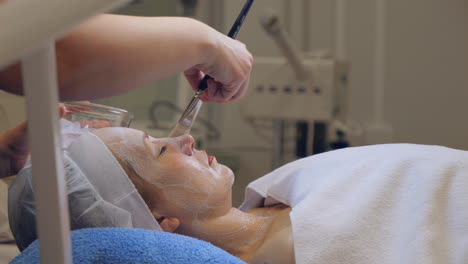 Relaxed-woman-Receives-facial-treatment-in-a-spa-in-calm-relaxing-atmosphere