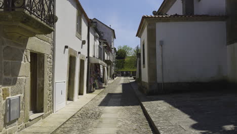 Historic-quiet-cobblestone-street-with-thin-walkway,-natural-brown-tan-colored-walls