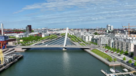 Aerial-view-approaching-the-Cruselli-bridge,-summer-in-Ruoholahti,-Helsinki