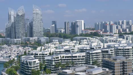 Zeitlupen-Landschaftsansicht-Der-Türme-Und-Des-Marina-Resorts-In-Der-Hafenfront-Der-Keppel-Bay-Mit-Der-Skyline-Der-Stadt-Singapur-Im-CBD-Im-Hintergrund,-Asiatische-Architektur