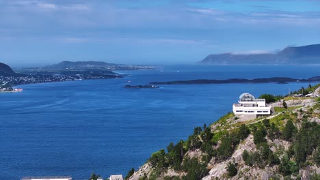 Luftaufnahme-Des-Aussichtspunktgebäudes,-Des-Fjords-Und-Der-Inseln-In-Alesund,-Norwegen-An-Einem-Sonnigen-Sommertag,-Drohnenaufnahme-Mit-60 fps