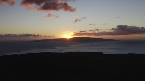 Sun-bursts-flare-as-it-sets-on-Kahoolawe,-dusk-glow-spreads-on-horizon-and-clouds