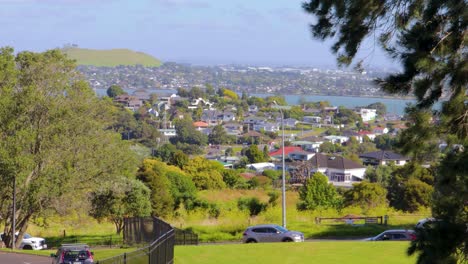 Vista-Panorámica,-Tráfico-Por-Carretera-En-El-Campo-De-Nueva-Zelanda,-Auckland,-Autos-Ocupados-Conduciendo-Con-Fondo-De-Ciudad