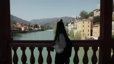 Female-Photographer-On-The-Historic-Wooden-Bridge-Of-Ponte-Vecchio-In-Bassano-del-Grappa,-Italy