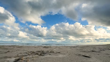 Clouds-over-a-sandy-beach,-time-lapse