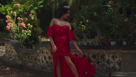 Amidst-the-history-laden-halls-of-a-Caribbean-castle,-a-young-woman-graces-the-scene-in-her-elegant-red-gown