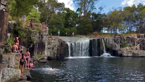 Niños-Y-Adultos-Saltan-Al-Río-En-La-Cascada-De-Charlie-En-Un-Día-Soleado-De-Verano-En-Nueva-Zelanda