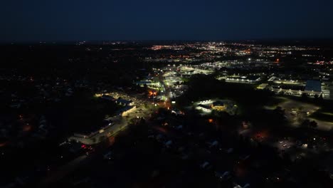 Vuelo-Aéreo-Sobre-La-Iluminación-De-La-Ciudad-Americana-Por-La-Noche-Con-Tráfico-En-La-Carretera