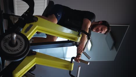 Vertical-shot-of-bearded-male-at-gym-perform-back-exercise-with-low-row-machine