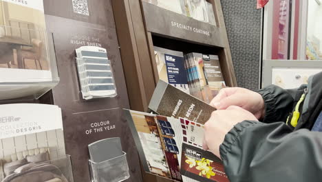 Man-taking-a-color-card-to-match-paint-color-samples-inside-Home-Depot-store