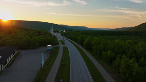 Aerial-view-flying-along-the-Utsjoentie-E75,-midnight-sun-in-Utsjoki,-Finland