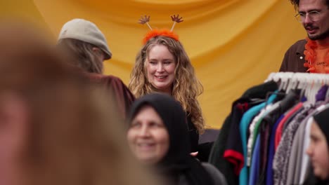 Friendly-white-Dutch-woman-with-King's-Day-head-decoration-in-curly-hair-smiles-close-up