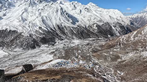 Looking-along-the-rugged-mountain-ridge-of-Kyanjin-Ri-into-the-vast-valley-of-Langtang-river-surrounded-by-pristine-snowy-summits-against-a-blue-sky