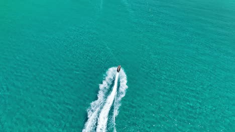 Speedboat-carving-white-waves-in-blue-Ionian-Sea-waters-near-Corfu-Island,-Greece,-aerial-view