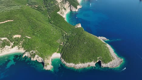 Liniodoros-nest-cave-on-corfu-island,-showcasing-the-lush-greenery-and-clear-waters-of-the-ionic-sea,-aerial-view