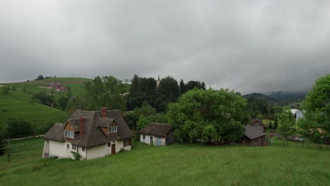 Green-village-landscape-with-church-and-houses-among-lush-trees-on-overcast-day