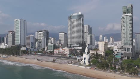 An-immersive-aerial-perspective-of-Nha-Trang's-skyline,-where-clouds-playfully-dance-above-the-cityscape,-casting-ever-changing-shadows-over-the-bustling-streets