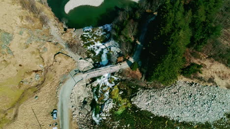 Kreisförmige-Luftaufnahme-über-Einen-Kleinen-Wasserfall,-Der-In-Einen-Pool-In-Norwegen-Fließt