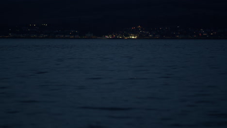 Low-angle-telephoto-compressed-view-of-coastal-town-lights-on-at-night