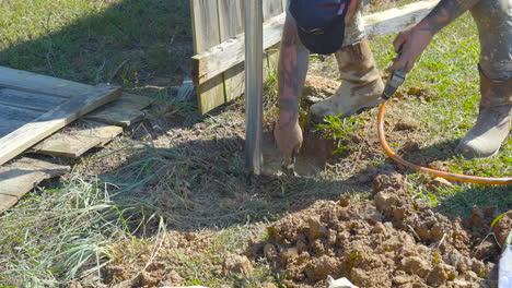 Construction-worker-preparing-a-post-hole-for-cement