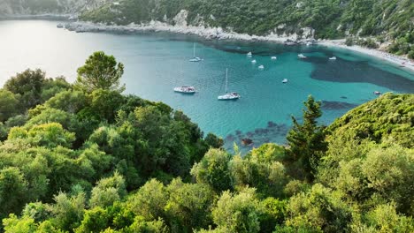 Üppiges-Grün-Umrahmt-Das-Ruhige-Blaue-Wasser-Des-Strandes-Von-Liapades,-Korfu-Bei-Sonnenuntergang,-Luftaufnahme