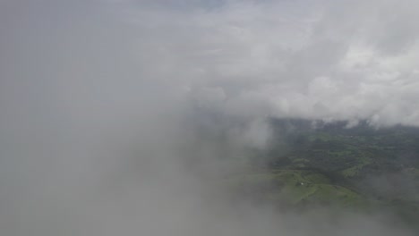 Bosque-Exuberante-Que-Se-Asoma-A-Través-De-Nubes-Blancas,-Creando-Una-Atmósfera-Serena,-Vista-Aérea