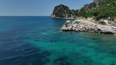 Kristallklares-Blaues-Wasser-Entlang-Der-Felsigen-Küste-Der-Insel-Korfu-In-Griechenland,-Luftaufnahme