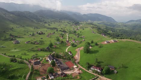 Sirnea-village-in-romania-with-lush-greenery,-traditional-houses-and-winding-roads,-summer-day,-aerial-view