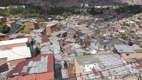 Dense-rooftops-of-Comuna-13-with-city-backdrop-in-Medellin,-Colombia