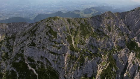 Rugged-peaks-of-Piatra-Craiului-Mountains-under-the-bright-daylight,-aerial-view