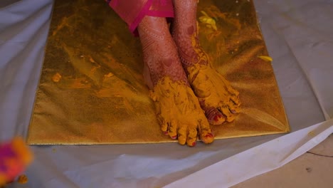 Close-Up-Of-Turmeric-Paste-On-Bride's-Feet-During-Pithi-Ceremony-Celebration