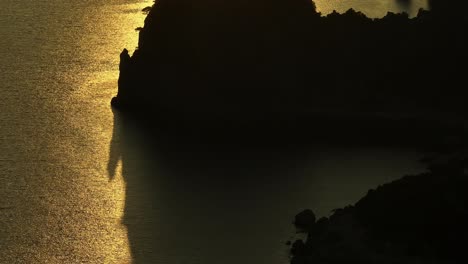 Goldener-Sonnenuntergang-über-Dem-Ionischen-Meer,-Der-Eine-Ruhige-Silhouette-Der-Zerklüfteten-Küste-Der-Insel-Korfu-Wirft