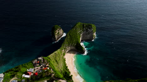 Buildings-at-cliff-edge-overlooking-Kelingking-Beach-of-Nusa-Penida-island,-Bali-in-Indonesia