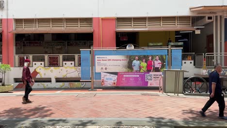 Menschen-Gehen-Vor-Dem-Hintergrund-Des-Banners-Der-Minister-Josephine-Teo,-Heng-Chee-How,-Denise-Phua-Und-Wan-Rizal-Von-Jalan-Besar-GRC-In-Der-Waterloo-Street,-Innenstadt-Von-Singapur