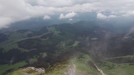 Eine-Bergkette-Mit-Wolken,-Die-über-üppigen-Wäldern-In-Großer-Höhe-Schweben,-Ruhige-Landschaft,-Luftaufnahme