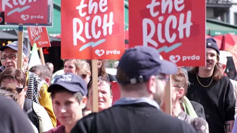 Demonstrators-holding-'Tax-the-Rich'-signs-at-protest