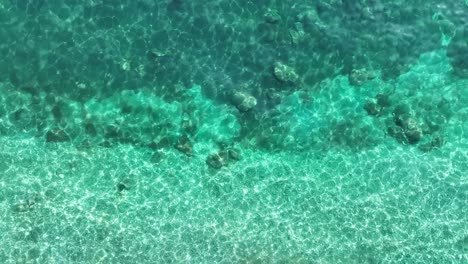 Kristallklares,-Türkisfarbenes-Wasser-Umspült-Sanft-Die-Küste-Der-Insel-Korfu,-Sonnenbeschienener-Unterwasserblick
