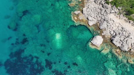 Luftaufnahme-Des-Türkisfarbenen-Wassers-Entlang-Der-Insel-Korfu,-Griechenland,-Mit-Blick-Auf-Die-Felsige-Küste