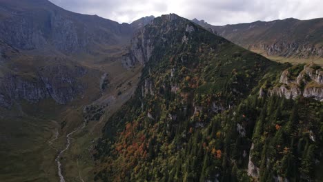 Herbstfarben-Hüllen-Die-Schroffen-Bucegi-Berge-In-Eine-Lebendige-Decke,-Luftaufnahme-Im-Morgengrauen