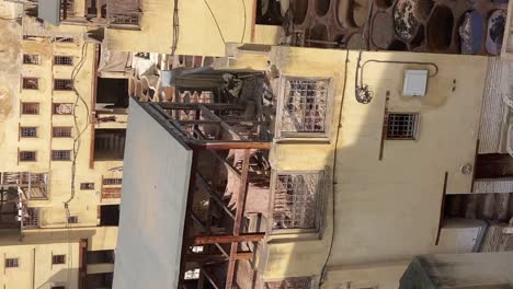 VERTICAL,-Workers-in-traditional-Leather-Tannery-hanging-Skin-to-dry,-Fez-Morocco